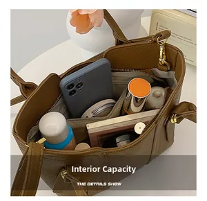 Macro detail showing interior storage compartments and large capacity of the brown tote bag