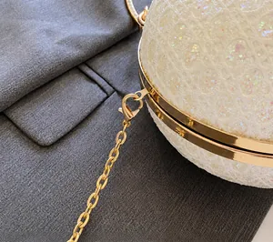 Dettaglio della borsa da sera con paillettes bianche e tracolla a catena oro