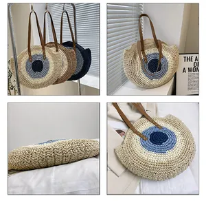 Detail of round straw tote bag featuring bohemian evil eye pattern and leather straps