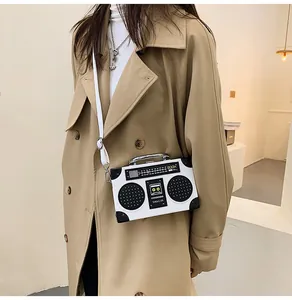 Dettaglio borsa a tracolla a forma di radio vintage con stampa BOOM su pelle bianca