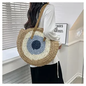 Detail of round straw beach bag with colorful weaving and durable leather shoulder straps