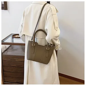 Detailed back view of a khaki textured bucket bag styled with a classic beige trench coat