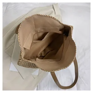 Top view of woven tote bag showing fabric lining, zipper pocket and leather strap details