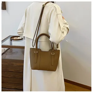 Detail shot of brown lychee grain leather tote bag with adjustable shoulder strap and metal hardware