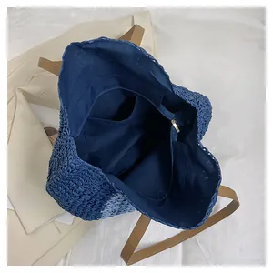 Internal view of the large blue woven tote bag showing lining and zipper pocket