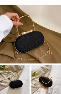 Detail of black glitter evening bag featuring gold bow clasp and metallic round handle