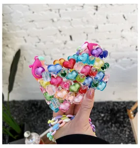 Gros plan de perles acryliques colorées en forme de cœur et fermoir mousqueton rose sur charm