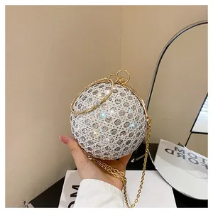 Detail of spherical evening clutch with silver rhinestones and gold ring handle