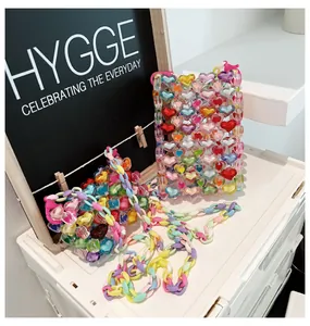 Détail de sacs faits main en perles de cœur avec bandoulières colorées en acrylique