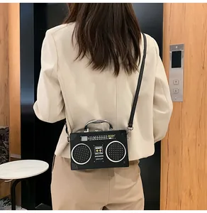 Dettaglio della borsa a tracolla stile radio vintage con motivi altoparlanti e manico in metallo
