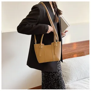 Detail of tan lychee grain leather tote bag with gold hardware and adjustable strap
