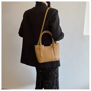 Detail of camel leather bucket bag showing refined litchi texture and gold hardware