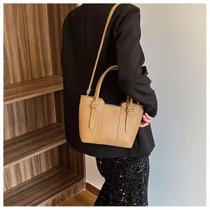 Detail of caramel leather handbag with lychee texture and adjustable shoulder strap