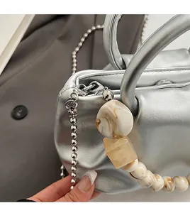 Détail de la texture argentée du sac avec perles décoratives à effet marbre