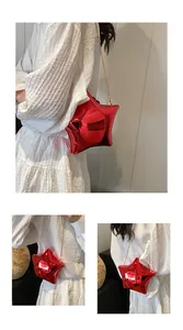 Detalle del bolso rojo con forma de estrella, acabado efecto espejo y cadena dorada