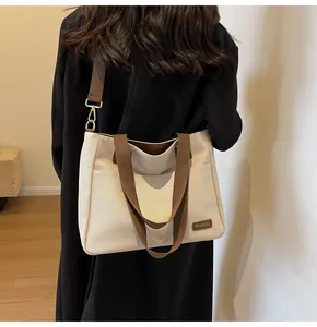 Detail view of khaki canvas tote bag with brown straps and side pocket for daily commute