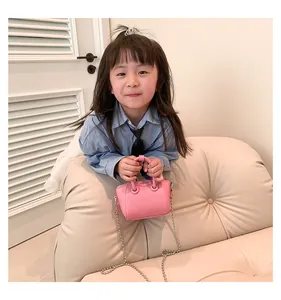 Detail view of pink textured leather mini bag for kids with silver ball chain strap