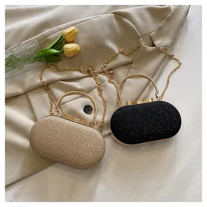 Detailed view of oval glitter evening bags with metal handles and bow clasps in gold and black