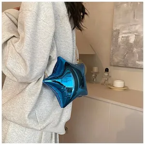 Macro detail of glossy blue star-shaped bag with puff texture and gold chain strap