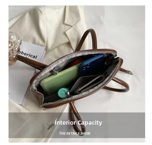 Internal capacity detail of a brown leather shoulder bag with multiple compartments
