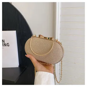 Macro detail of champagne glitter clutch bag with bow clasp and golden chain strap