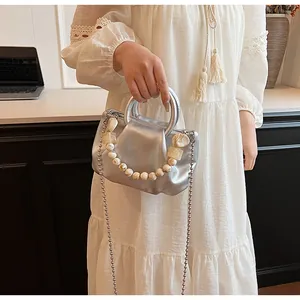 Détail du sac nuage plissé argenté avec chaîne en perles et poignée en métal