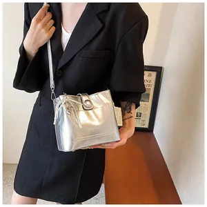 Détail du sac seau métallisé argenté avec bandoulière en perles et pendentif cœur