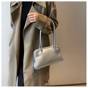 Detail of silver metallic underarm bag showing rectangular texture and logo embossing