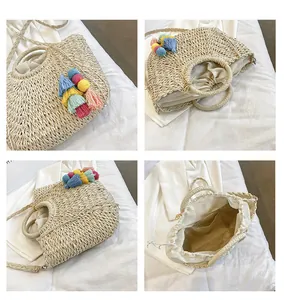 Detail of straw woven semi-circular bag with colorful tassel and drawstring inner lining