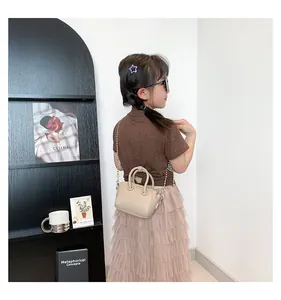 Mini beige lychee textured child handbag with elegant pearl chain strap detail