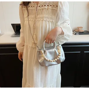 Sac à main nuage argenté plissé avec chaîne en perles dans un décor minimaliste