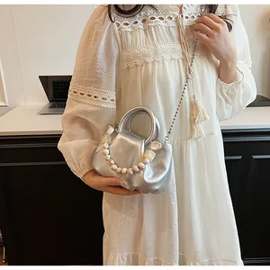 Détail du sac nuage plissé argenté avec poignée en perles marbrées et bandoulière chaîne