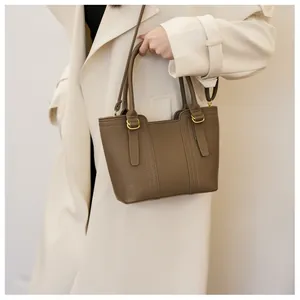 Detail view of the brown lychee pattern leather handbag with gold-tone hardware and straps