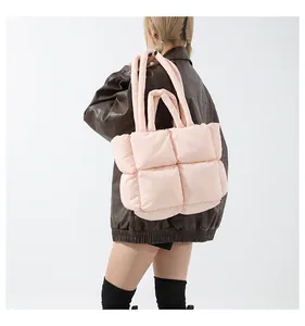 Detail of soft padded quilted tote bag in light pink with rounded top handles