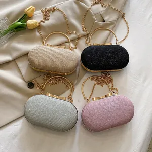 Glittery pill-shaped evening clutch bag with metal handle and chain for party wear