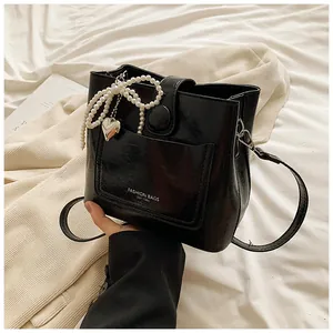Vue détaillée du sac seau noir avec pendentif cœur en perles et lettrage fashion bags