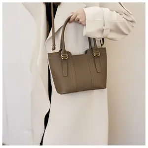 Detail of mocha brown bucket bag with lychee pattern leather and gold metal buckle