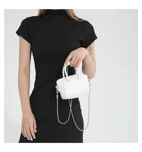 Detail of white pebbled leather mini Boston bag with silver bead chain strap and handles