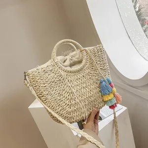 Detail of bohemian straw bag with colorful tassel and drawstring closure on display
