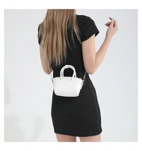 Back view of a mini white litchi pattern handbag with a silver chain strap on a model