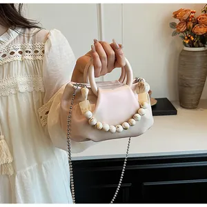 Détail du sac plissé avec chaîne en résine marbrée et bandoulière en métal rond