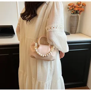 Détail du sac nuage plissé rose clair avec poignée en perles marbrées et chaîne