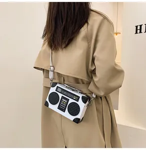 Detail of creative vintage boombox crossbody bag with adjustable white strap and silver buckle