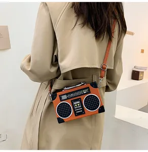 Retro Umhängetasche in Radio-Optik mit Vintage-Zifferblatt an Modell im Trenchcoat