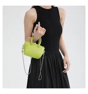 Detailed macro view of lime green lychee leather mini bag with silver bead chain strap