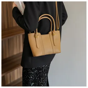 Brown lychee-grain faux leather bucket bag shown from a side-view on a model