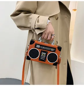 Detailansicht der orangefarbenen Umhängetasche in Retro-Radioform mit Silberbeschlägen