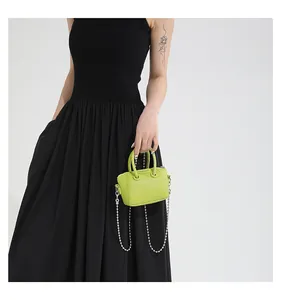 Detailed macro of lime green lychee leather mini bag with silver ring handle and chain