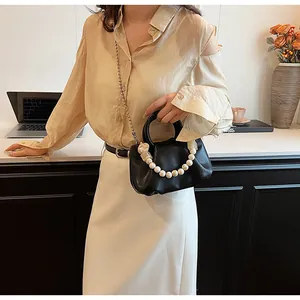 Détail du sac en cuir plissé noir avec poignée en perles et bandoulière