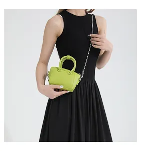 Detail of neon green pebble grain mini bag with silver ball chain and top handle